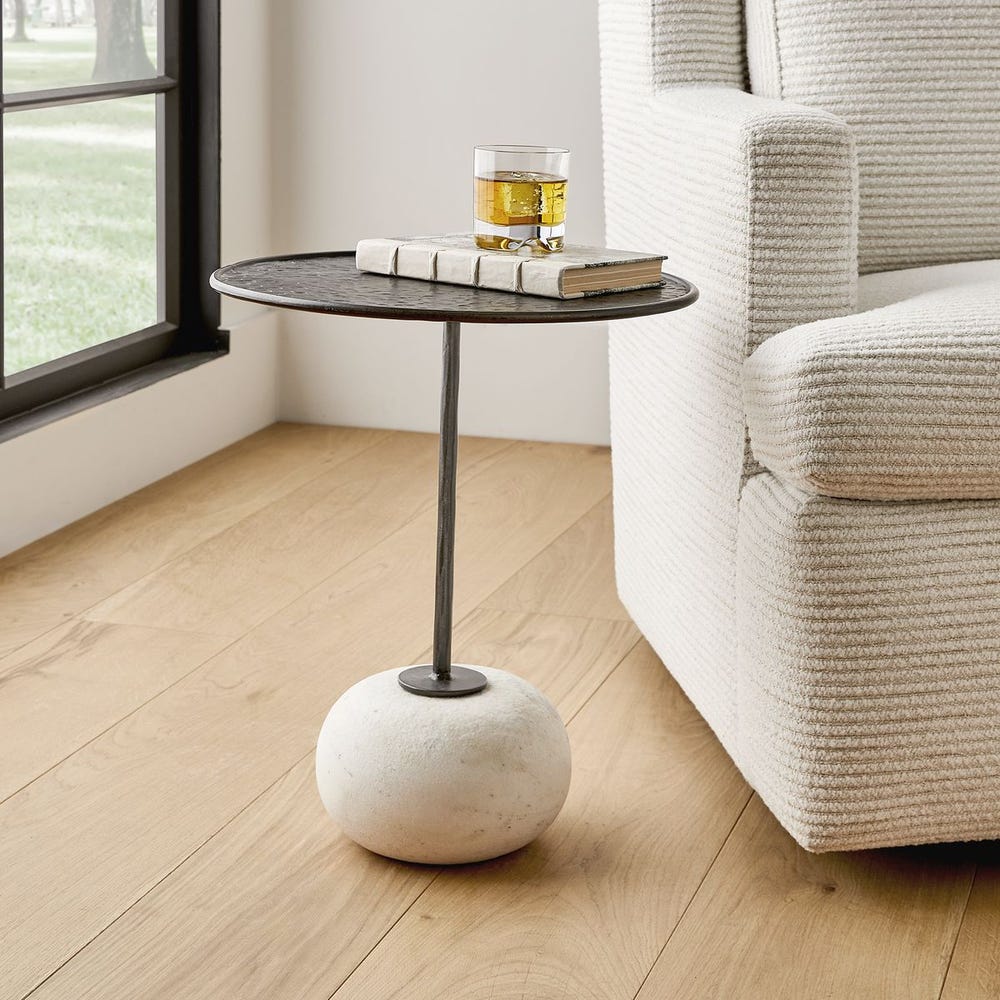 Sculptural accent table with weathered metal top and stone base – Rachel Blindauer