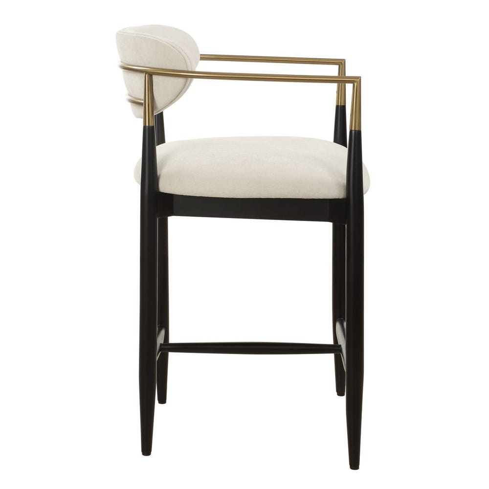 Mid-century modern counter stool with off-white velvet seat, matte black wood base, and brushed brass arms.