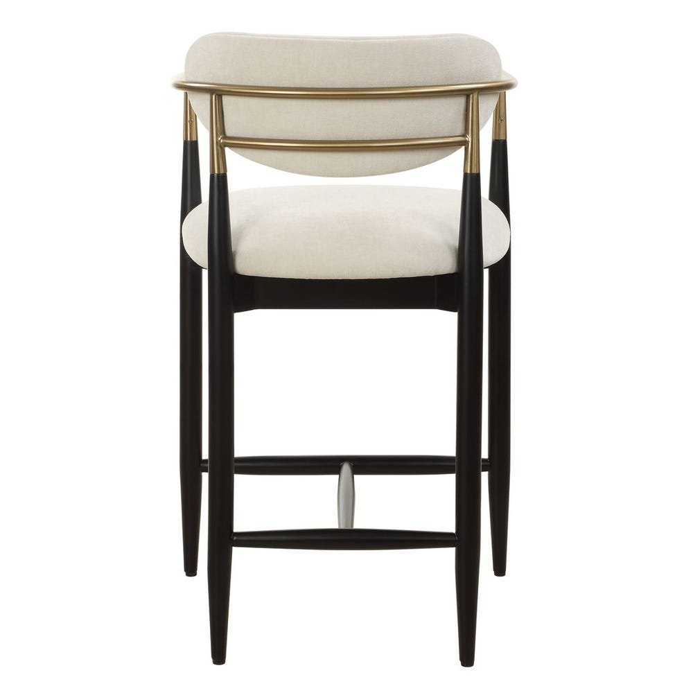 Mid-century modern counter stool with off-white velvet seat, matte black wood base, and brushed brass arms.