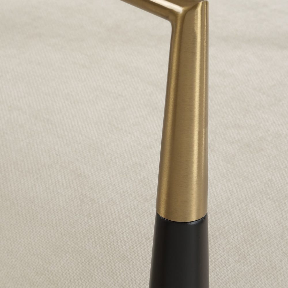Close-up of a gold and black arm rest on a textured fabric seat