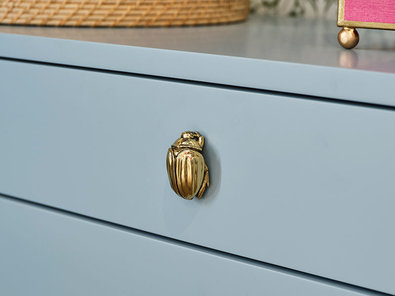 Light blue lacquered nightstand with soft curves and three drawers, featuring a whimsical brass beetle knob—perfect for modern bedrooms with personality.