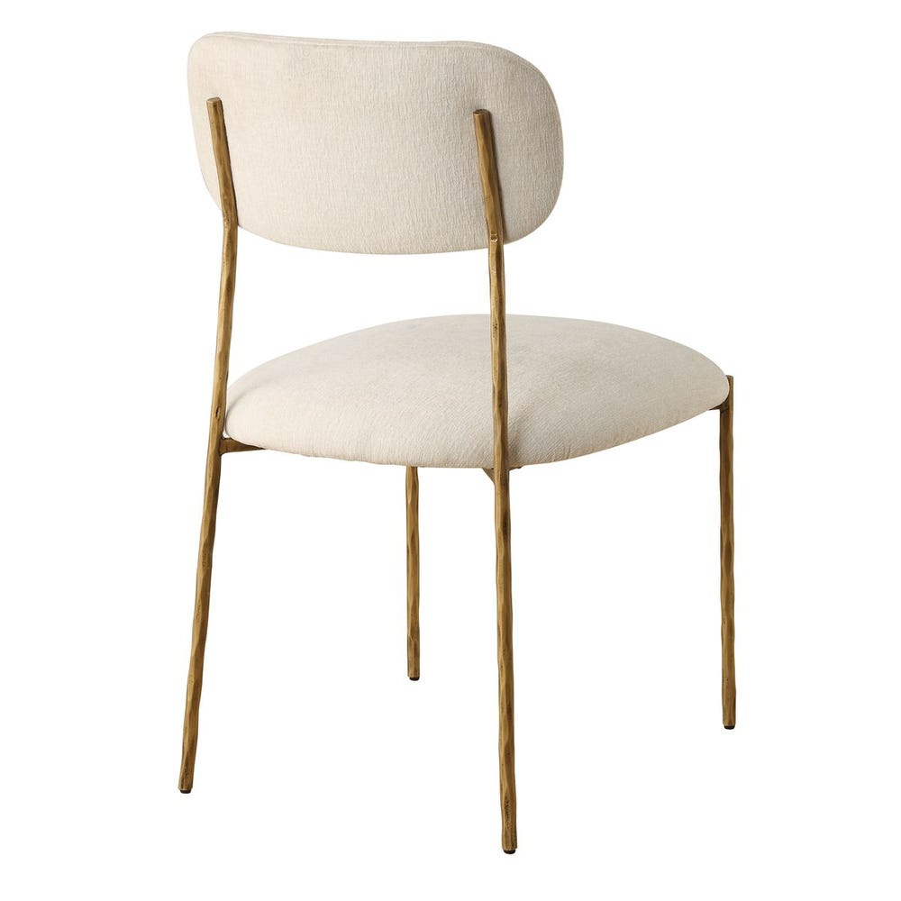 Sculptural iron dining chair with antique gold finish and floating off-white upholstered backrest.