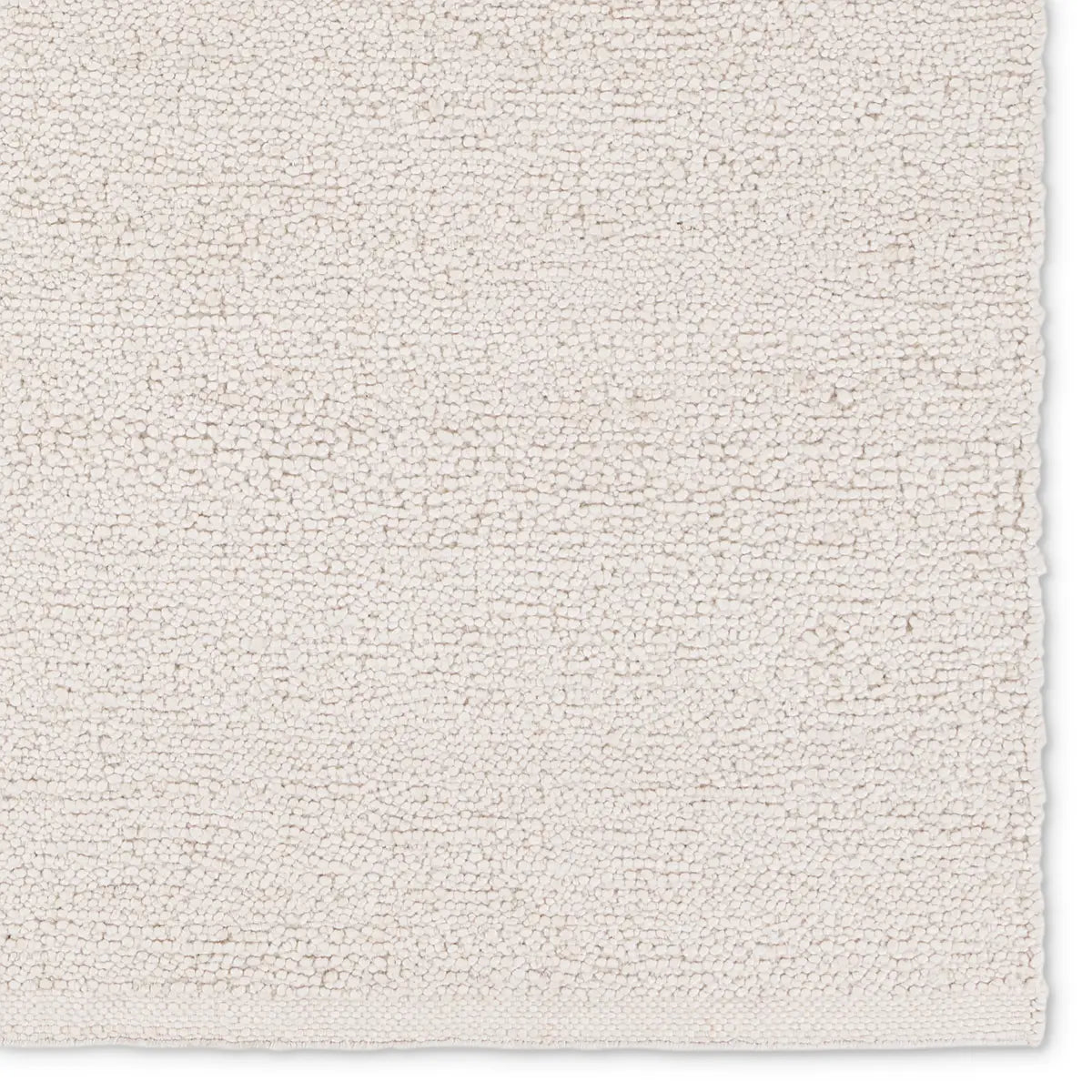 White handwoven rug with a raised bouclé texture, crafted from durable 100% PET yarn for indoor and outdoor use, designed for serene, coastal-inspired interiors.