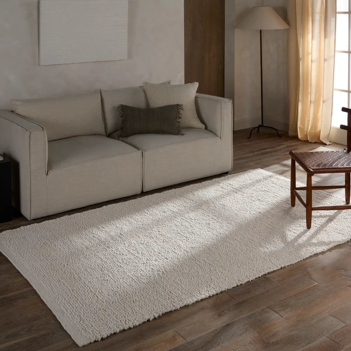 White handwoven rug with a raised bouclé texture, crafted from durable 100% PET yarn for indoor and outdoor use, designed for serene, coastal-inspired interiors.