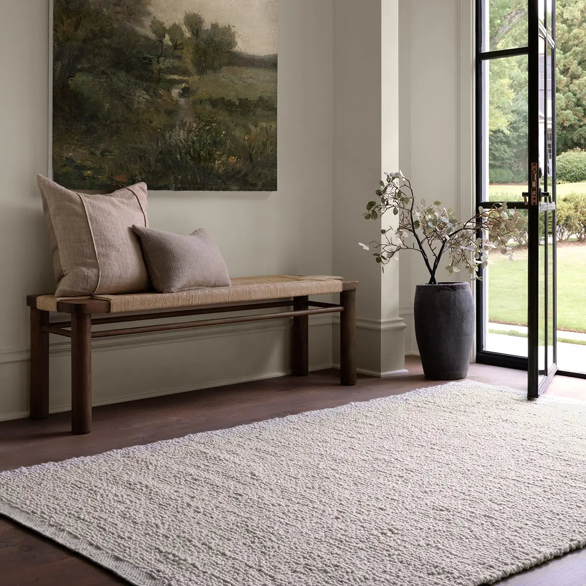 White handwoven rug with a raised bouclé texture, crafted from durable 100% PET yarn for indoor and outdoor use, designed for serene, coastal-inspired interiors.