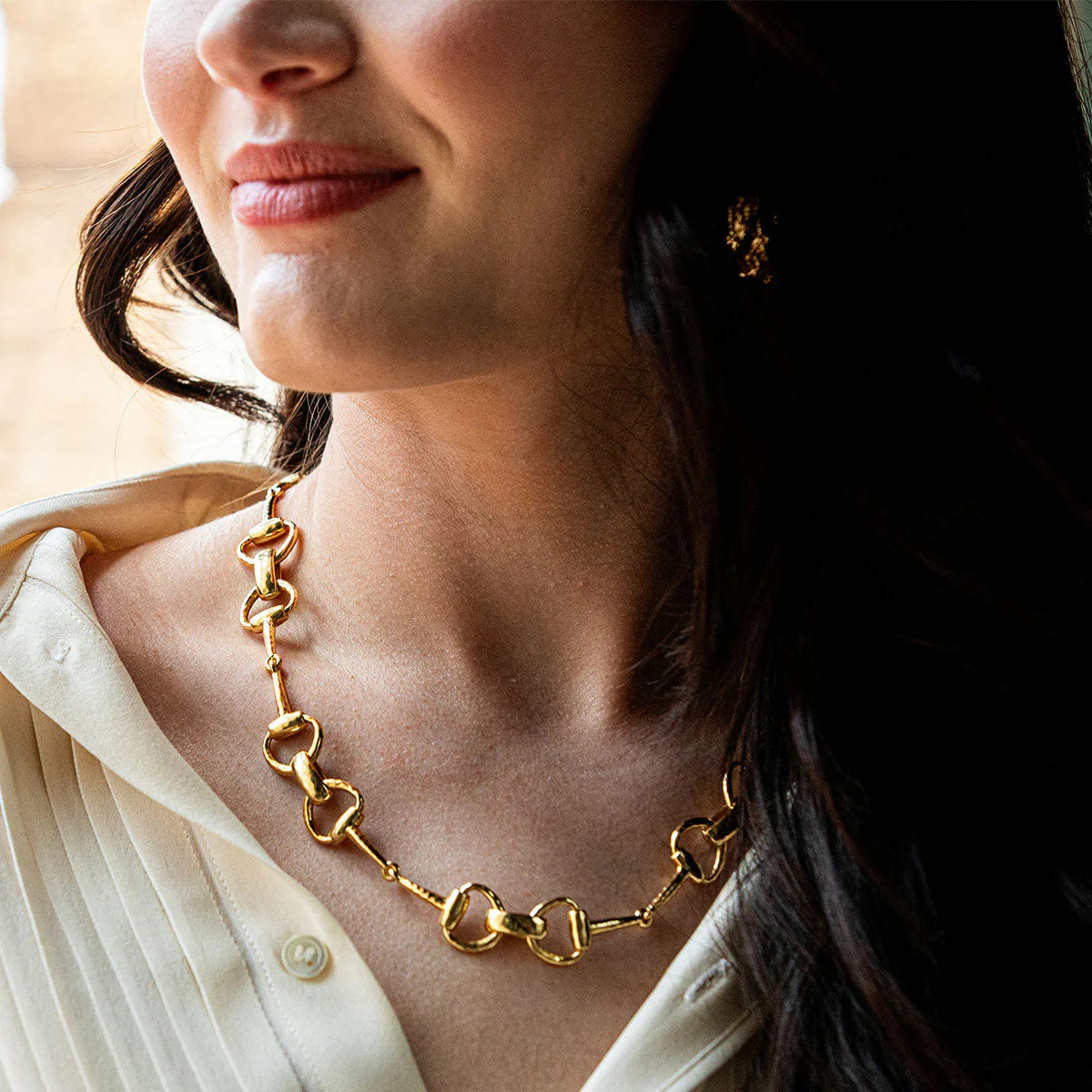 Gold-plated equestrian-inspired collar necklace with interlocking snaffle bit links, handcrafted and rich in heritage symbolism.