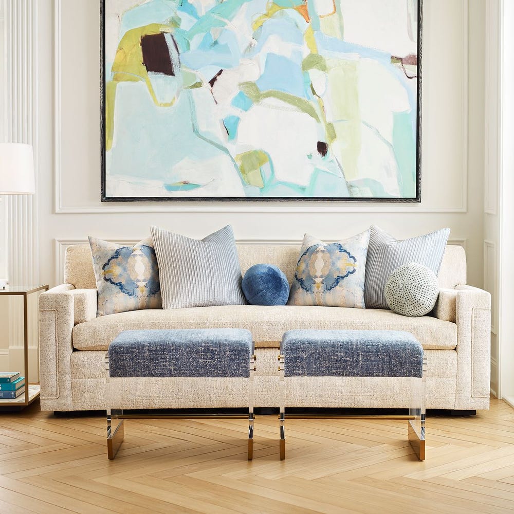 Round chenille ball pillow in sea salt and aqua dot pattern, styled on a beige sofa