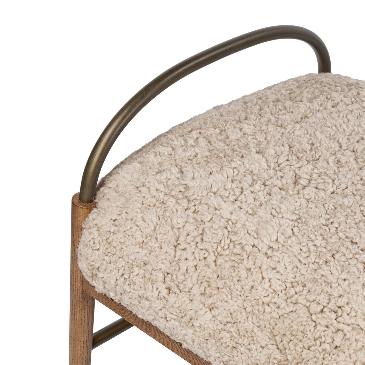 Close-up of a textured shearling cushion with a metal detail on a white background