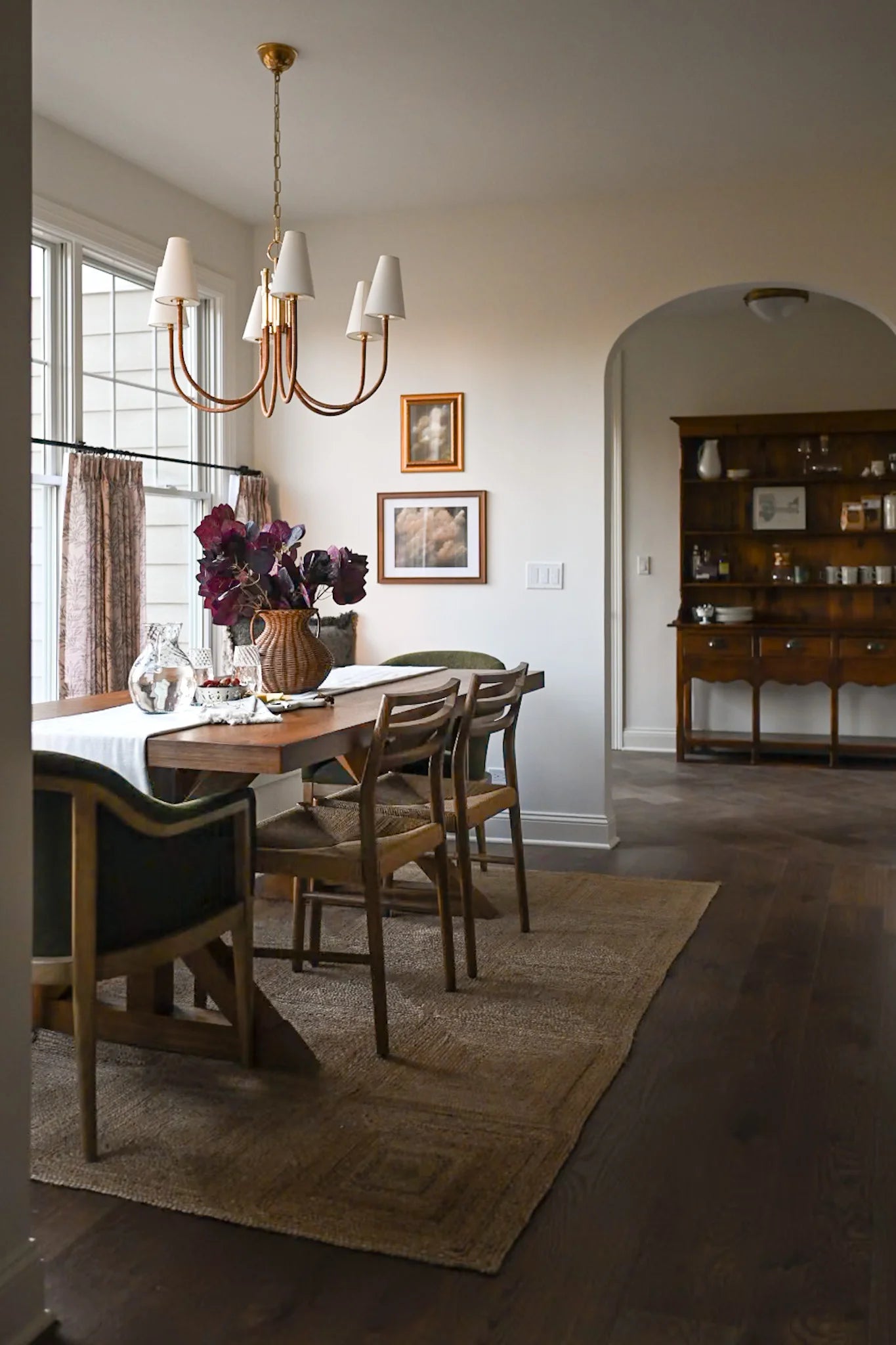 Dining room with wooden table, chairs, and Maris chandelier.