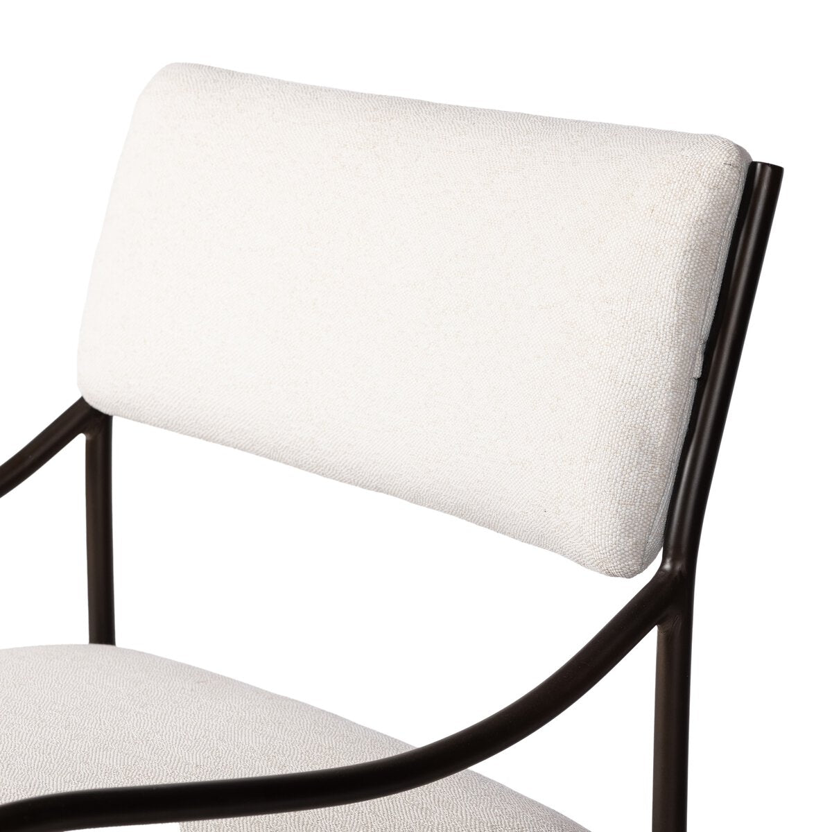 Outdoor lounge chair with curved matte gunmetal frame and handwoven linen-toned seat, styled for sculptural coastal living.