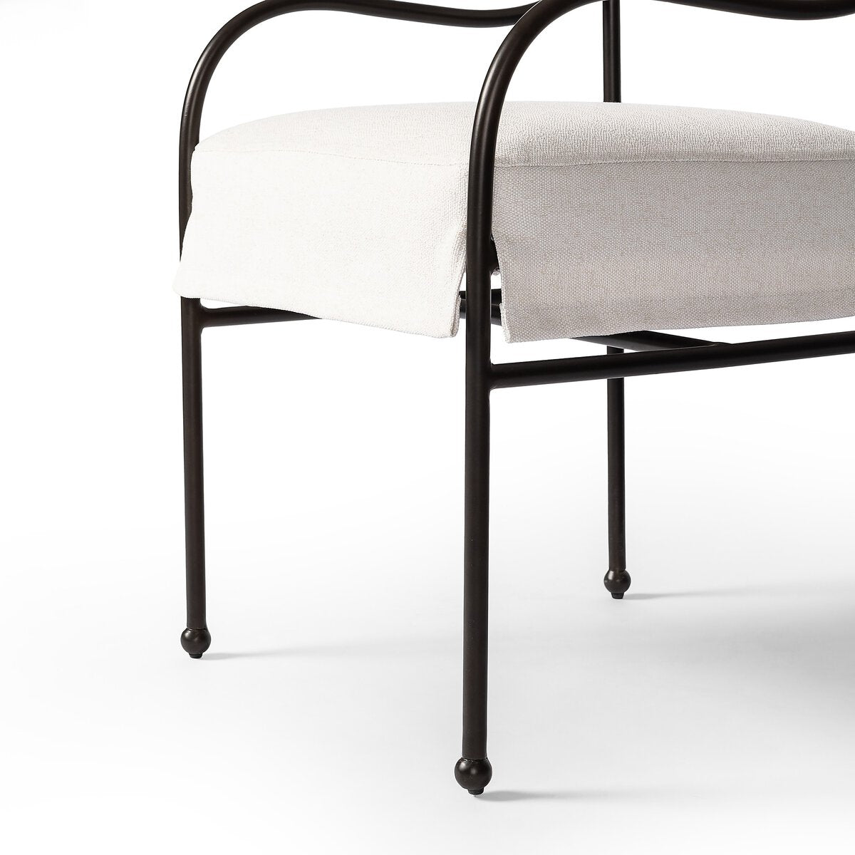 Sculptural outdoor dining chair with curved matte gunmetal frame and linen-toned all-weather weave, styled for refined alfresco dining.