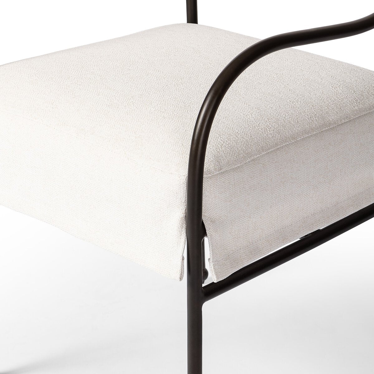 Sculptural outdoor dining chair with curved matte gunmetal frame and linen-toned all-weather weave, styled for refined alfresco dining.