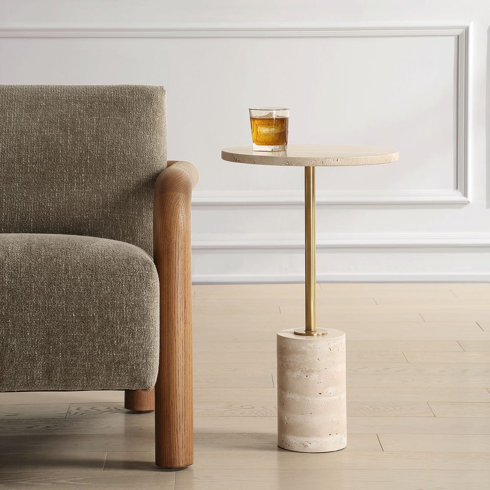 Sculptural travertine and brass pedestal table with creamy stone top and slim metal base—ideal as a drink table or side table.
