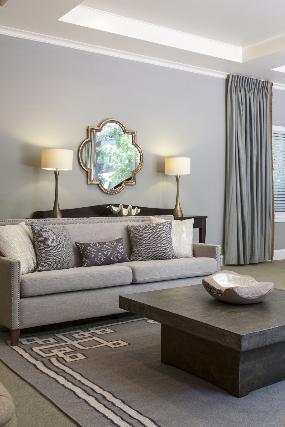 Valois Hammered Quatrefoil Mirror styled above a sofa in a living room designed by Rachel Blindauer