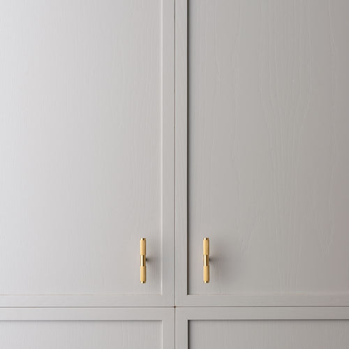 Axis brass cabinet pull installed on kitchen cabinetry