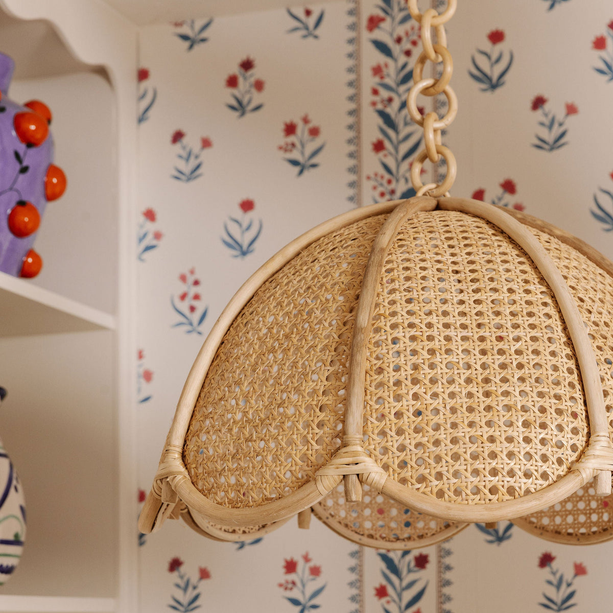 Cane dome pendant from below against floral wallpaper