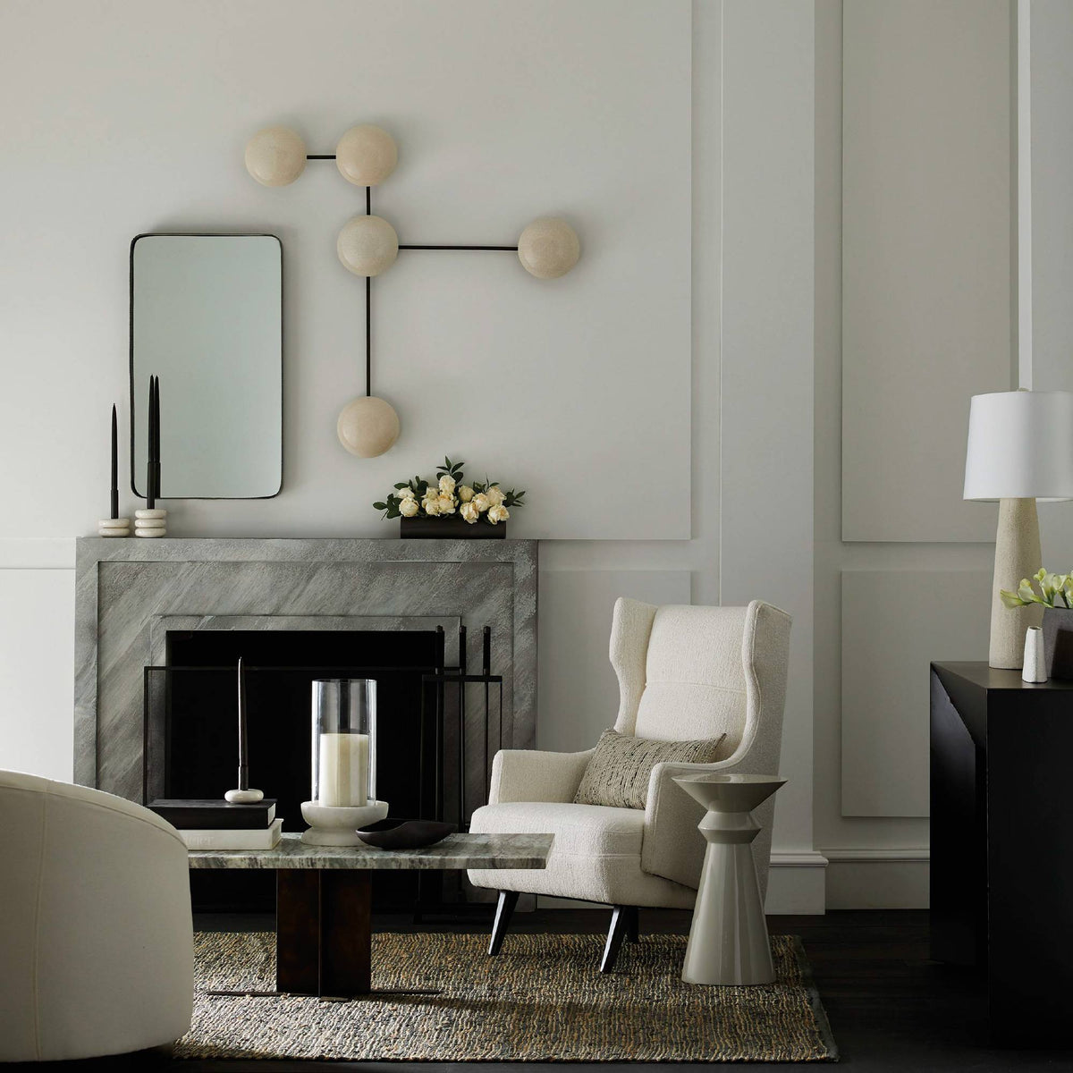 Ivory ceramic sculptural sconce above a fireplace in a neutral living room