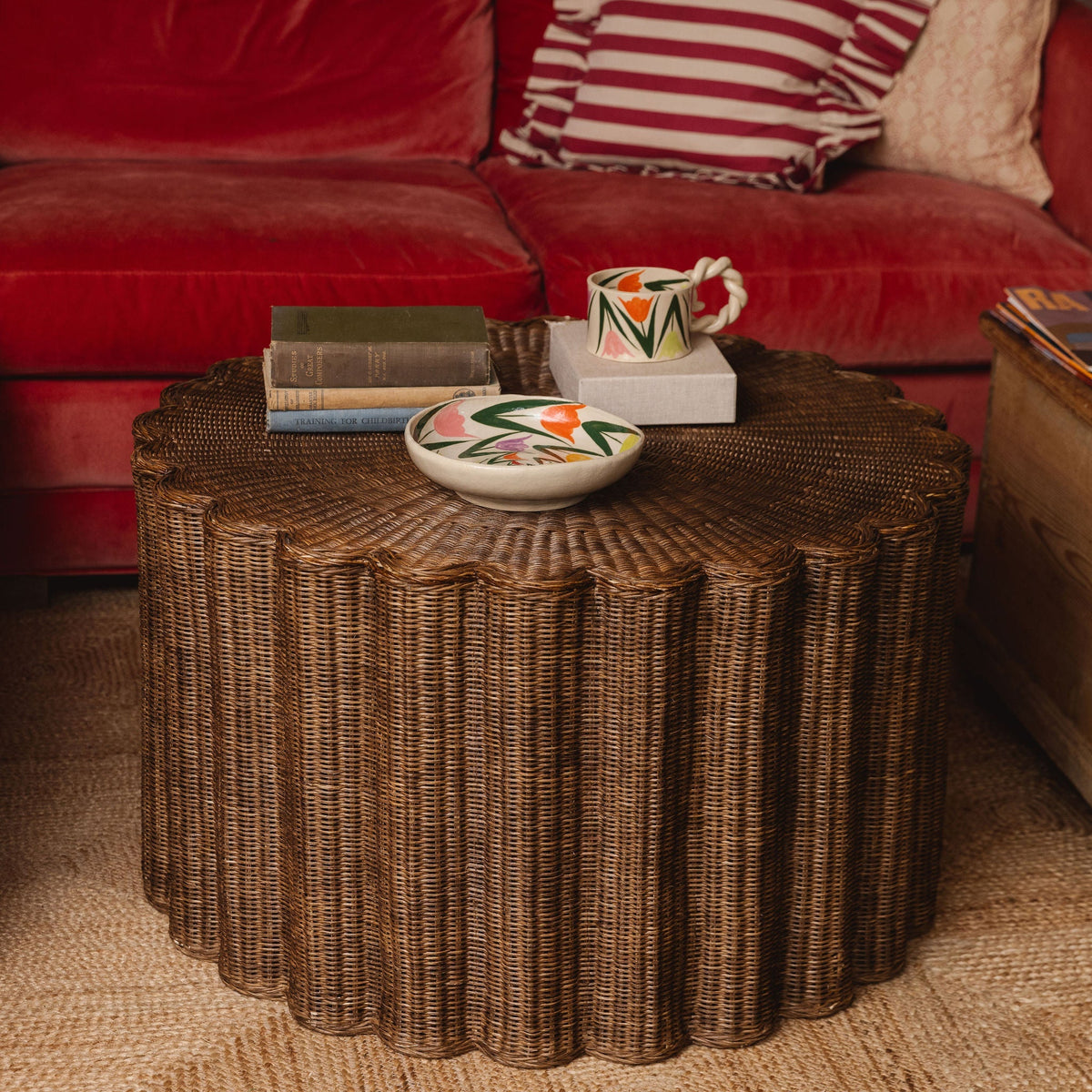 Corolla fluted rattan coffee table in front of a sofa on a jute rug