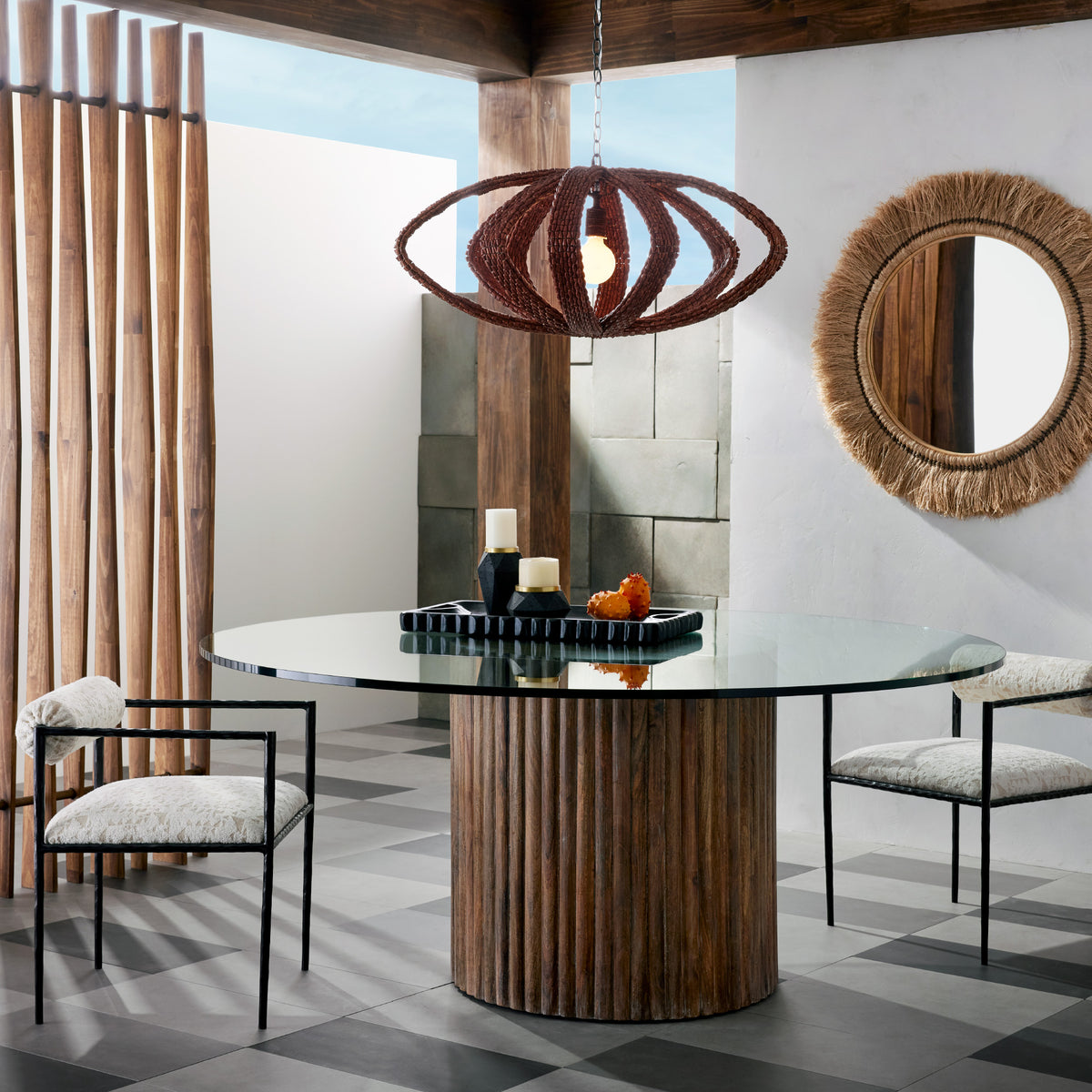 Natural abaca fringe round mirror above a dining table