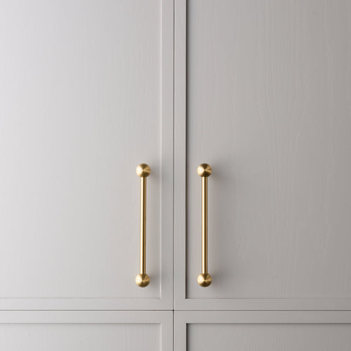Wand brass cabinet pull medium size installed on cabinetry