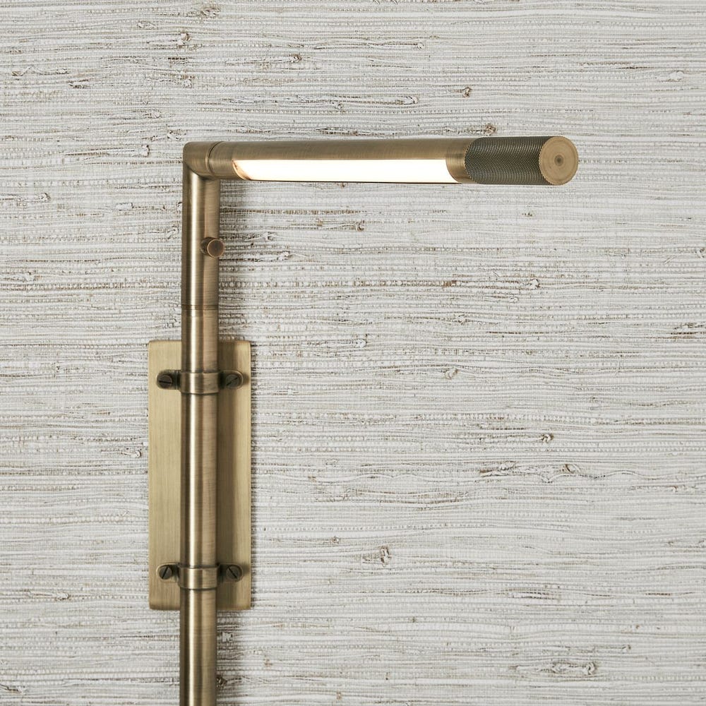 Antique brass wall sconce with adjustable rotating arm and integrated LED, styled for reading