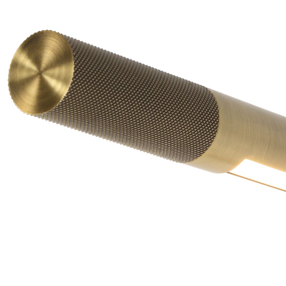Detail of Antique brass wall sconce with adjustable rotating arm and integrated LED, styled in a minimalist reading nook for warm, directional lighting.