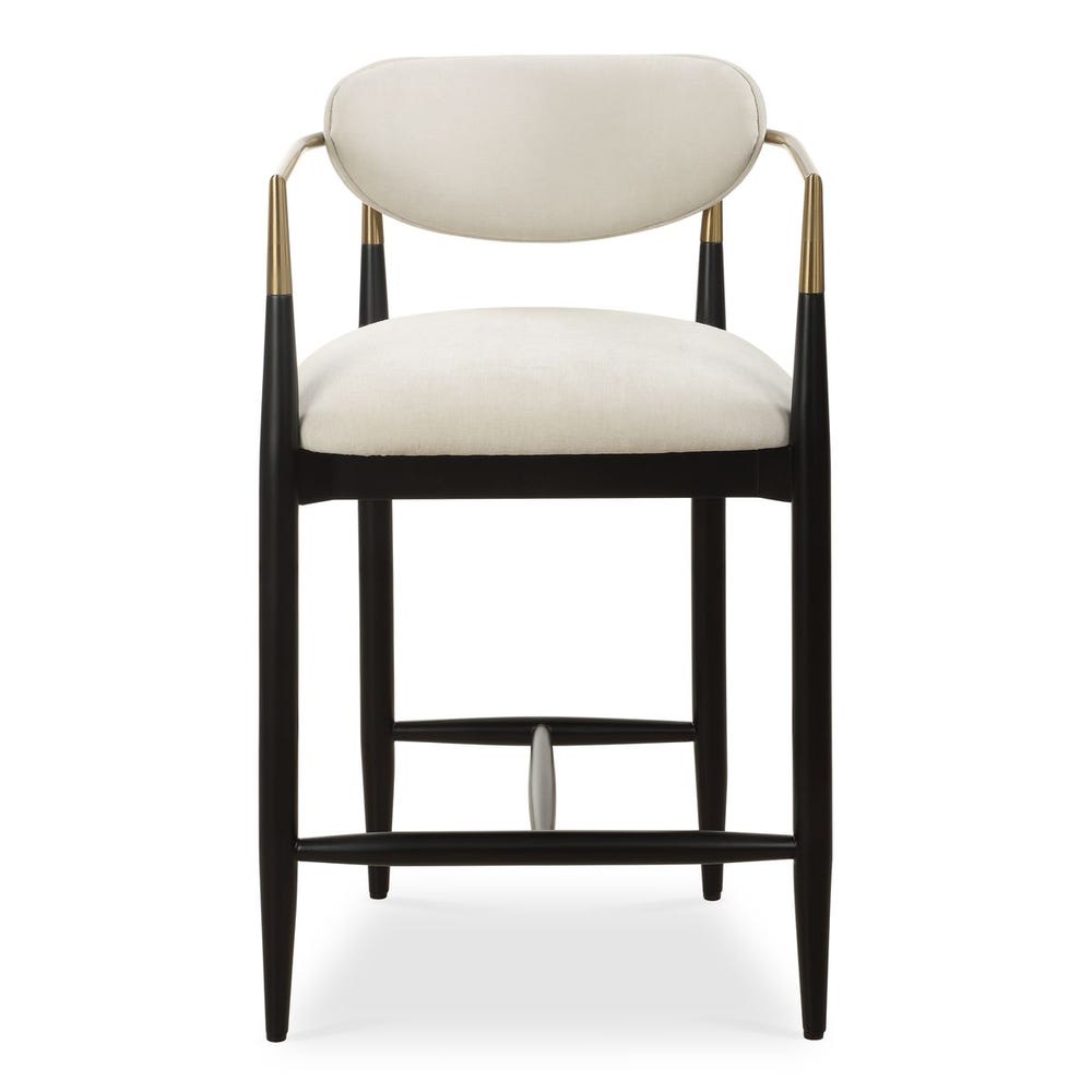 Mid-century modern counter stool with off-white velvet seat, matte black wood base, and brushed brass arms.