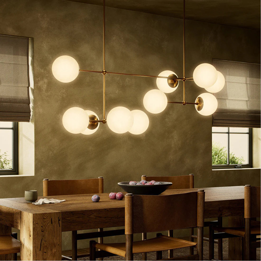 Modern linear chandelier with hand-blown glass globes and sculptural brass rods, ideal for dining rooms, islands, or dramatic entryways.