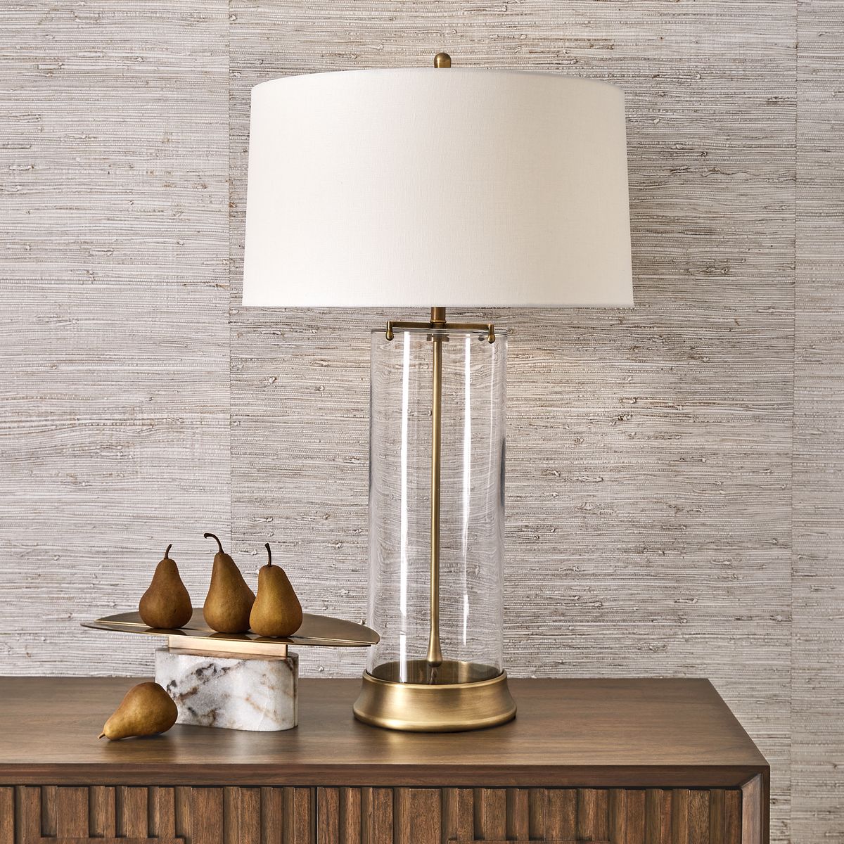 Eclipse Plinth Vessel in room with twin brass arcs and honed marble base, styled as a sculptural modern centerpiece on a console.