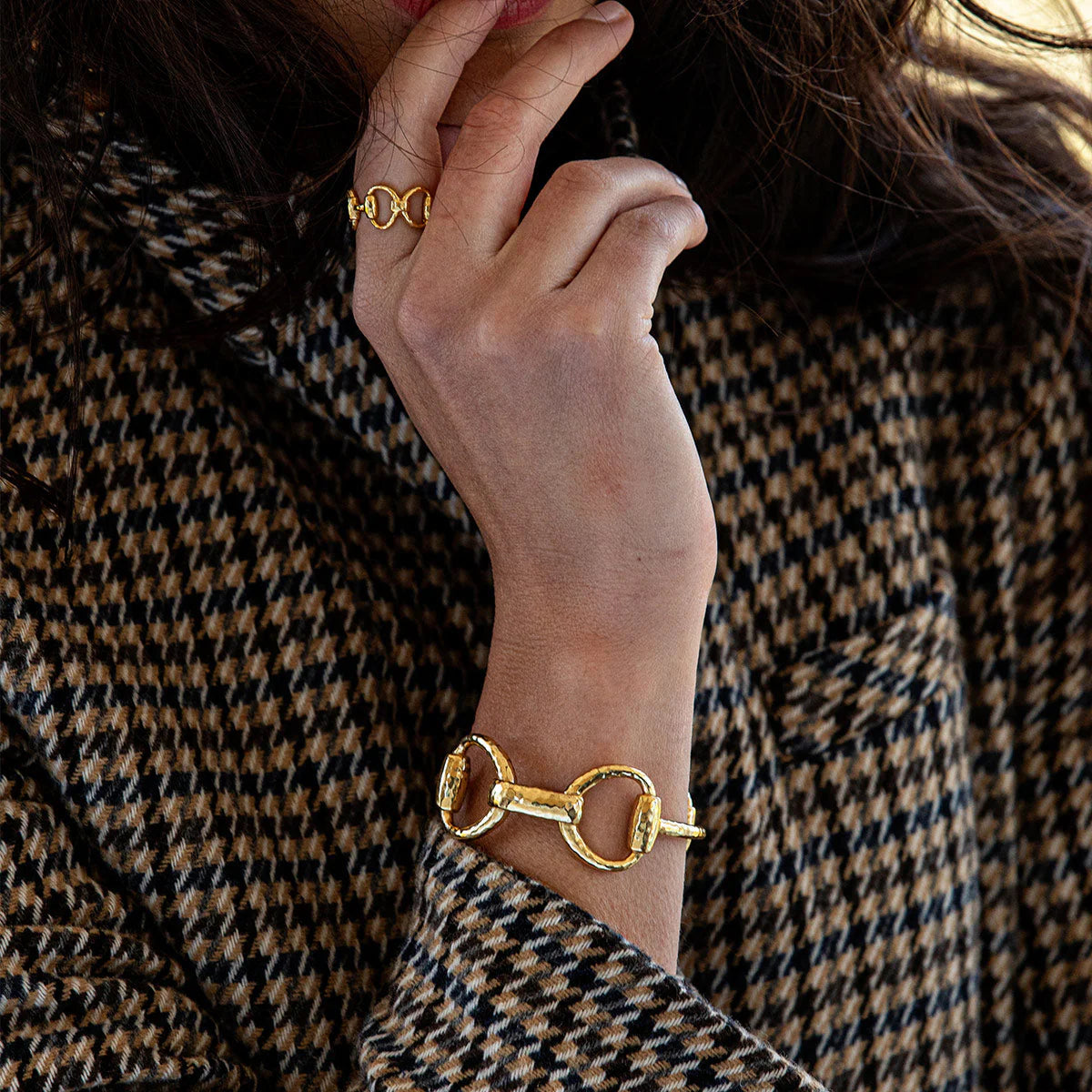 Gold equestrian snaffle bit cuff bracelet with oversized sculptural links, handmade in India, styled for effortless elegance.