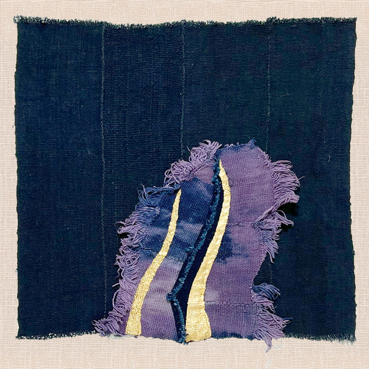 Detail of hand-stitched textile artwork with gold thread accents