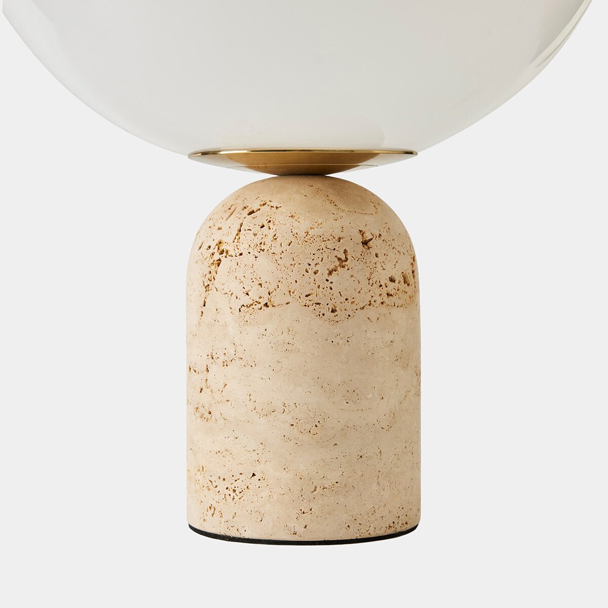 Luna Travertine Table Lamp illuminated — soft diffused glow through frosted glass globe, by Rachel Blindauer