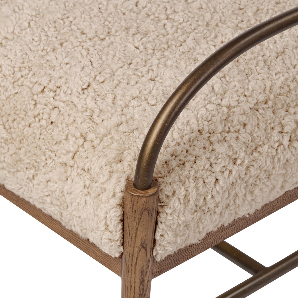 Close-up of a textured shearling cushion with a wood and metal frame