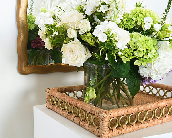 Rectangular rattan catchall tray with brass ring handles—ideal for styling coffee tables, organizing entryways, or serving drinks.