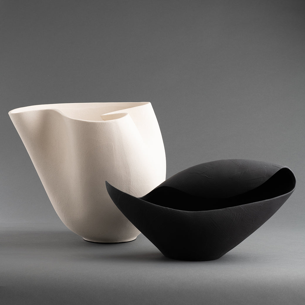 Off-white ceramic vase with an abstract sculptural silhouette, styled as a modern statement piece