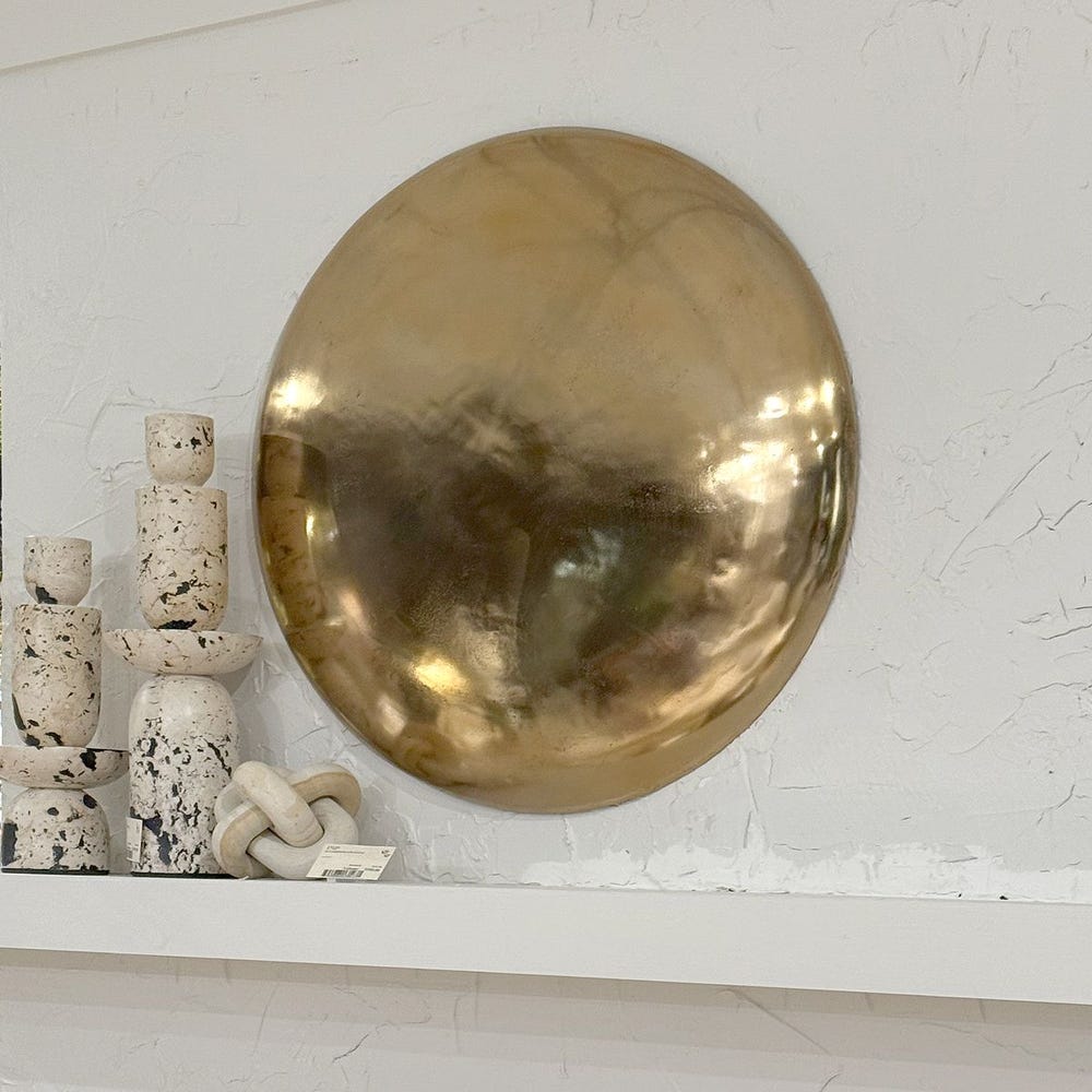 Reflective gold convex wall disc in sculptural cast aluminum, 32-inch diameter.