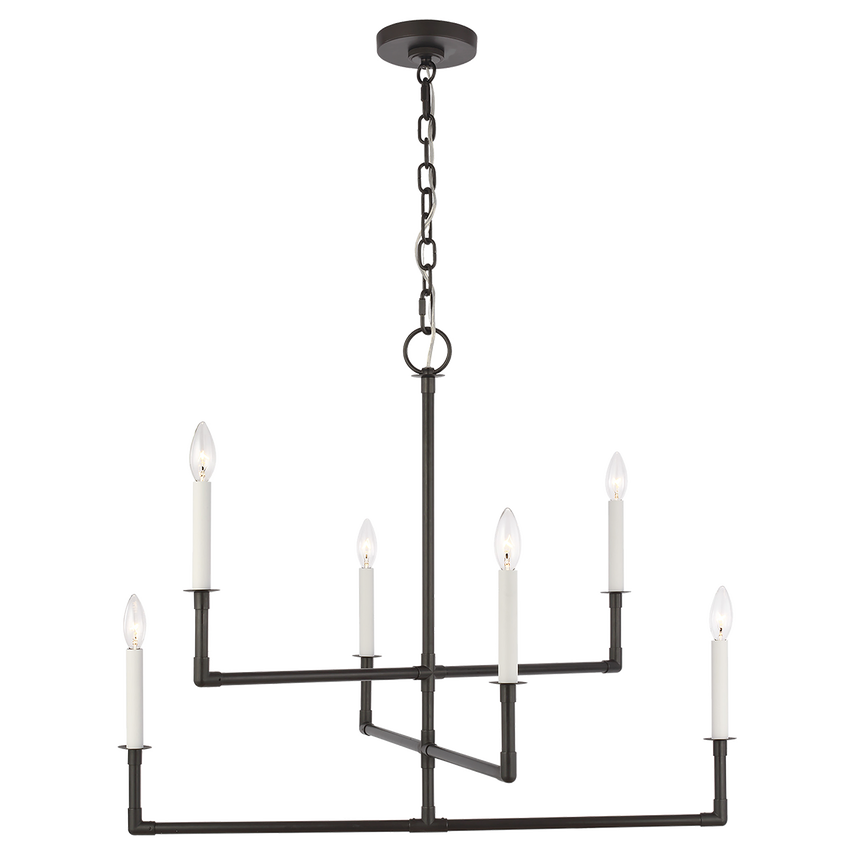 Medium-sized aged iron chandelier with sculptural linear frame and white candle-style sockets, suspended over a reclaimed wood dining table in a modern rustic interior.