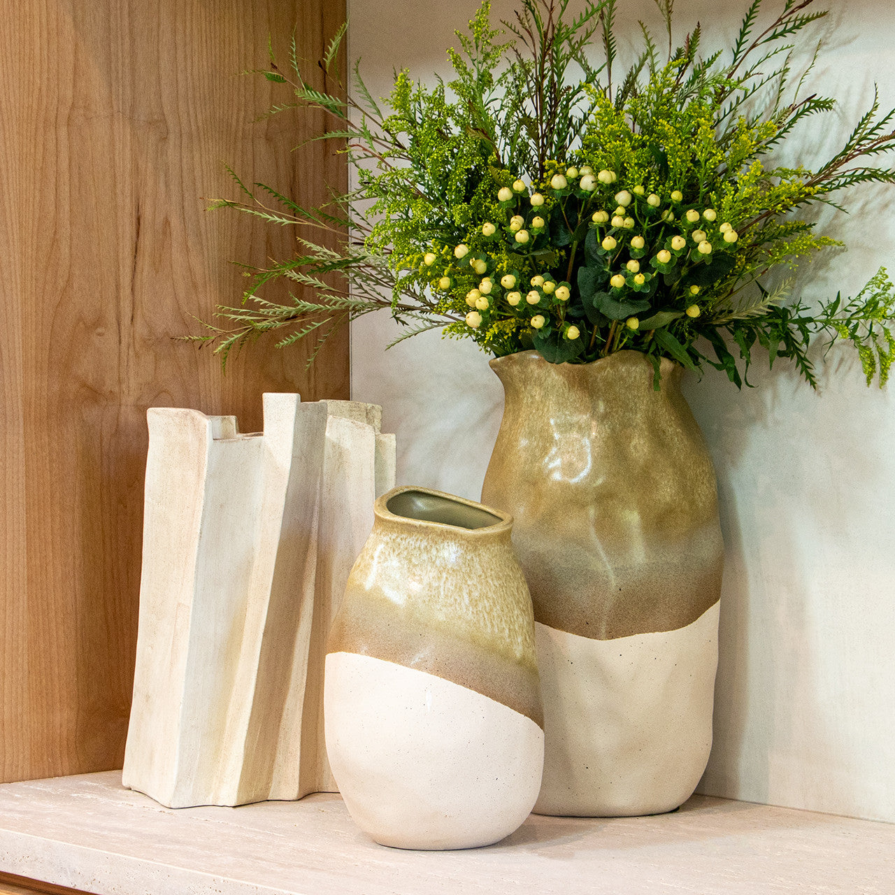 Modern sculptural vase in matte beige porcelain with folded ridges and rectangular form, styled as a standalone accent or with dried branches in minimalist interiors.