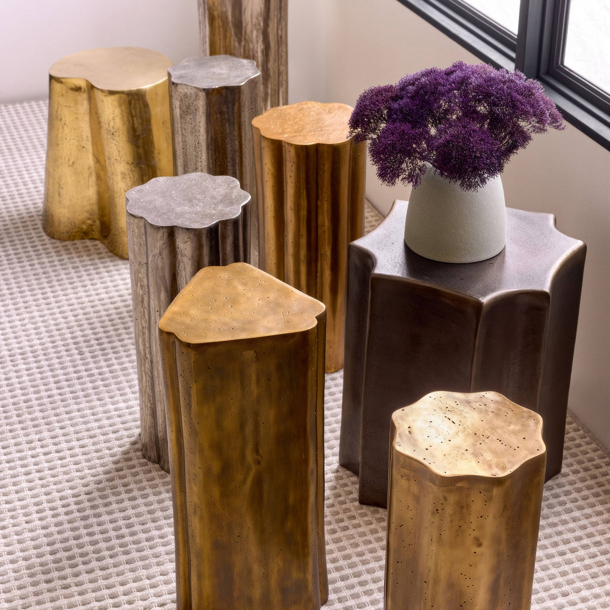 Cast brass stump accent table styled with other metal stump tables and flowers