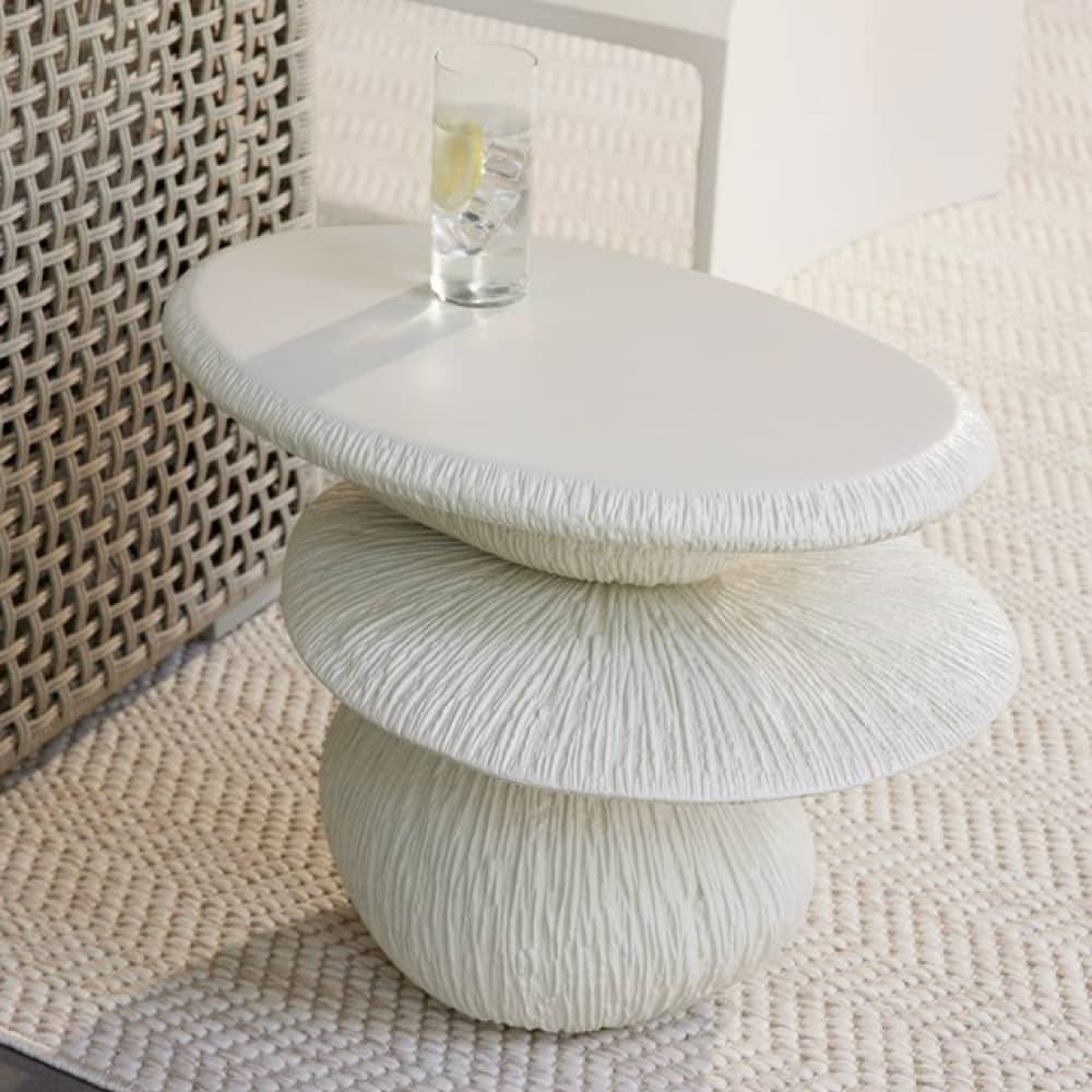Close view of the carved ivory side table holding a drink on a patio