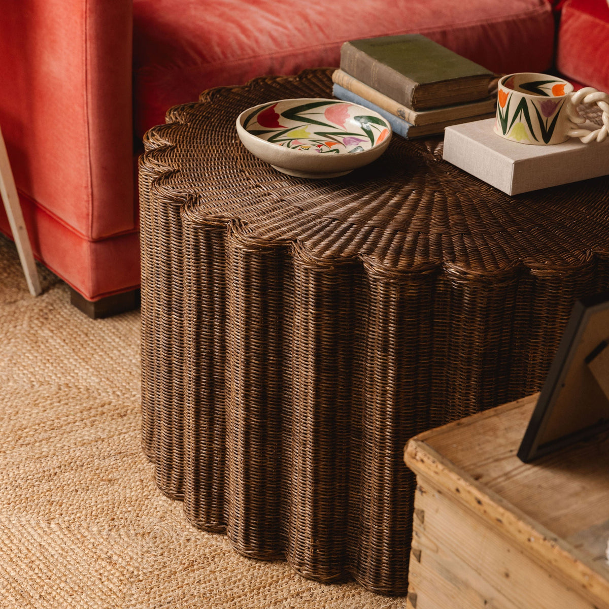 Teak rattan coffee table styled with books and a ceramic bowl