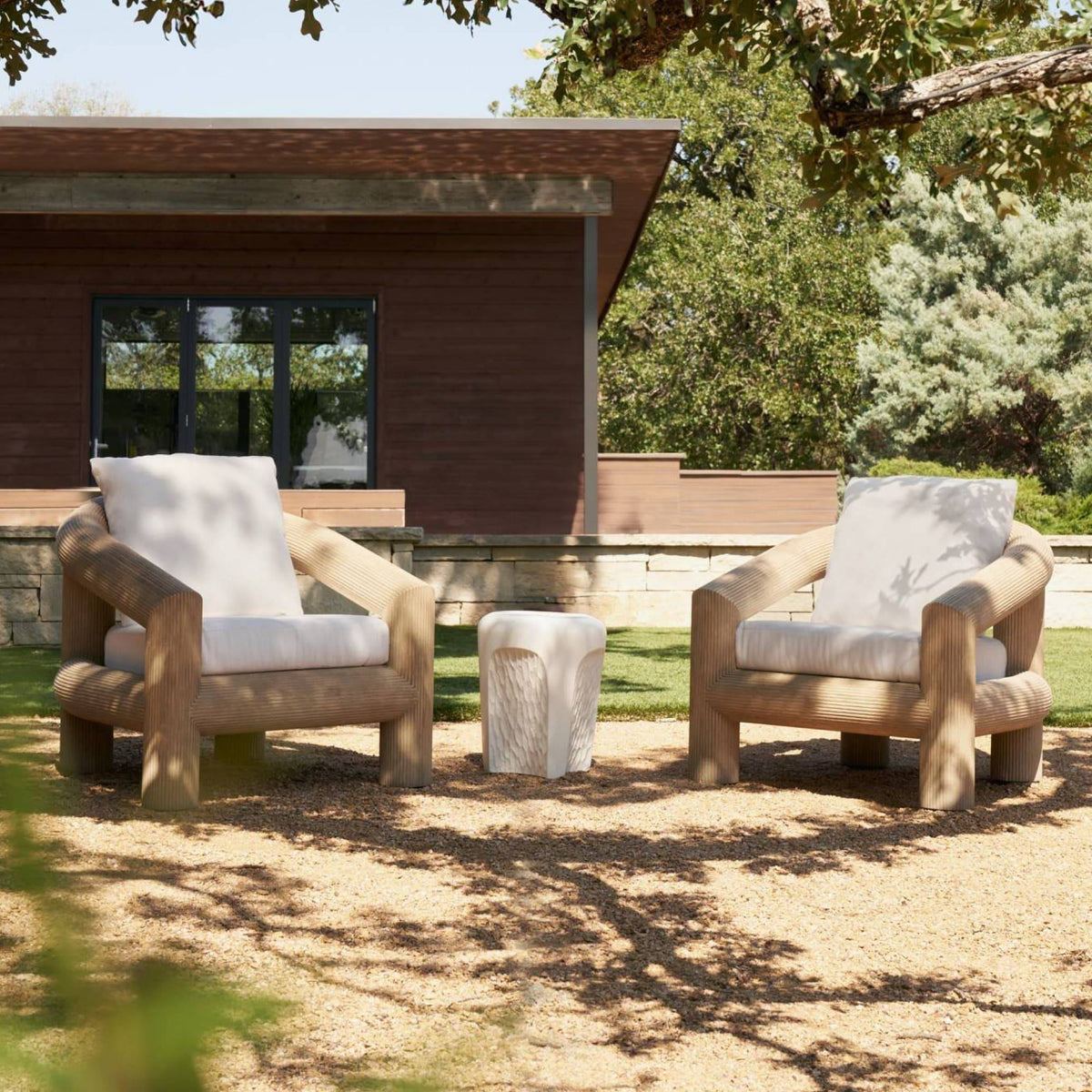 Pair of reeded teak lounge chairs on a garden patio