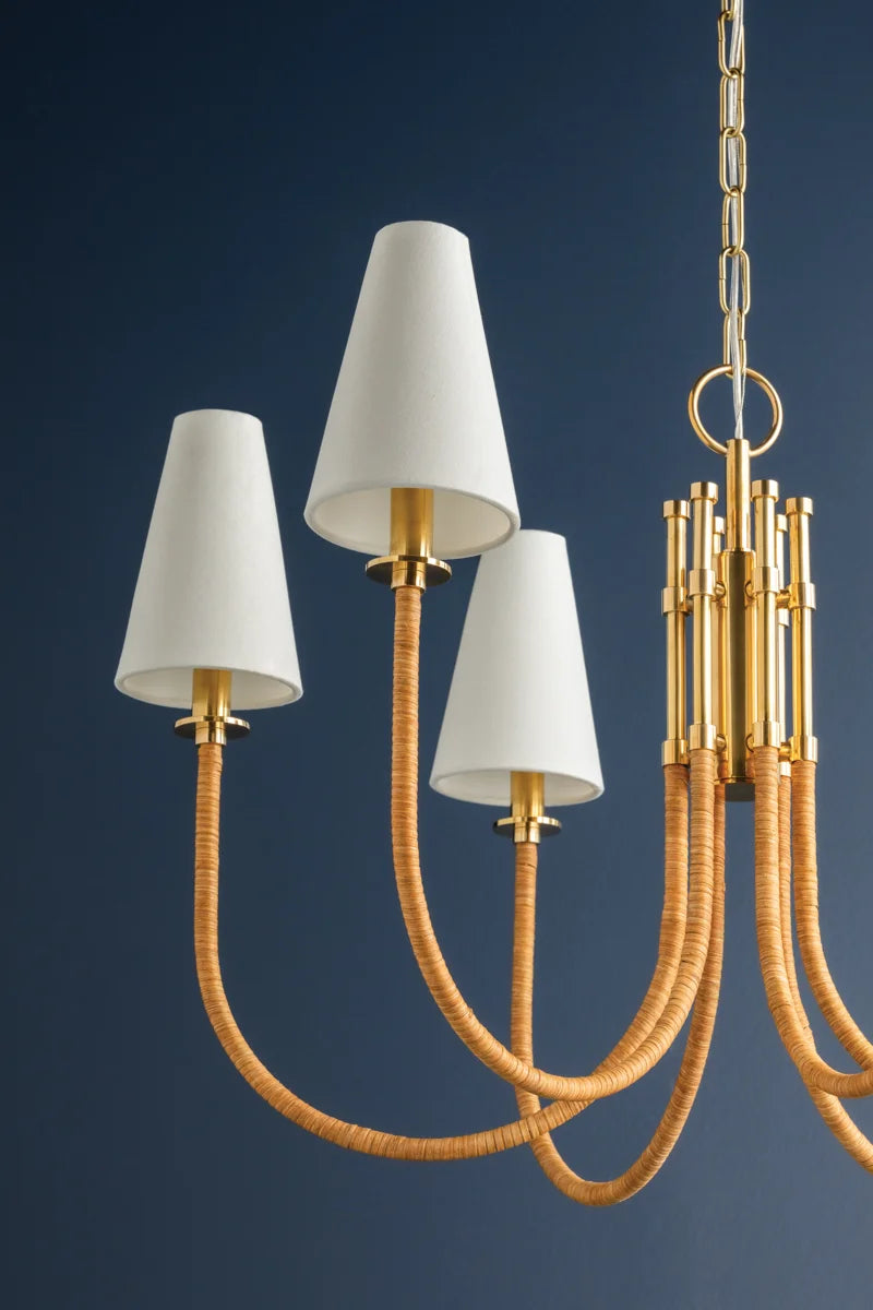 Chandelier with white lampshades and gold brass and handwoven rattan on a blue background