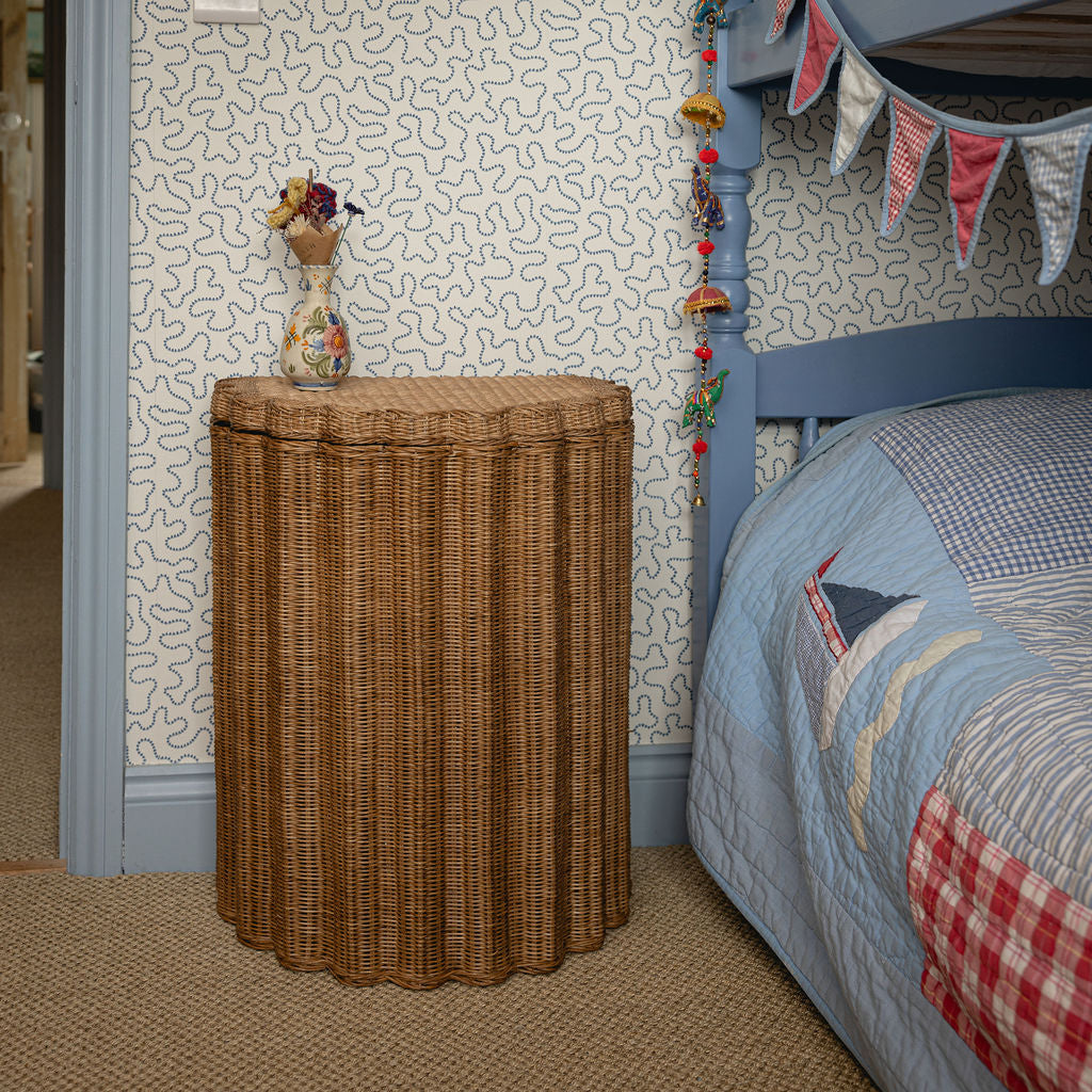 Light oak rattan nightstand used as a bedside table