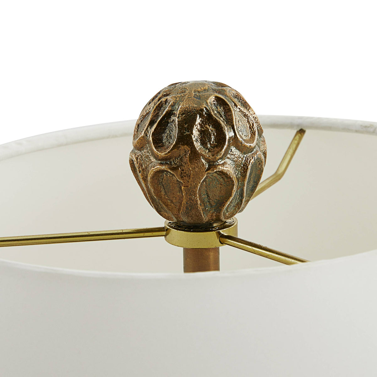 Sculpted brass globe finial on top of the lamp shade