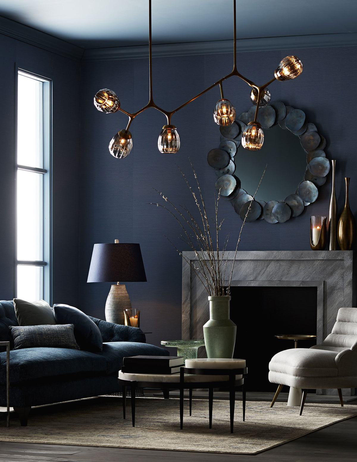 Iron disc round mirror over a fireplace in a moody living room