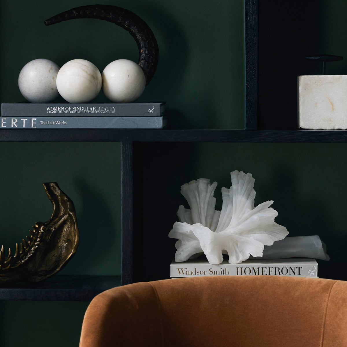 White ruffle mushroom sculpture styled on a dark bookshelf