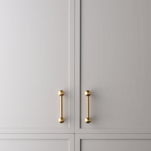 Wand brass cabinet pull small size installed on cabinetry