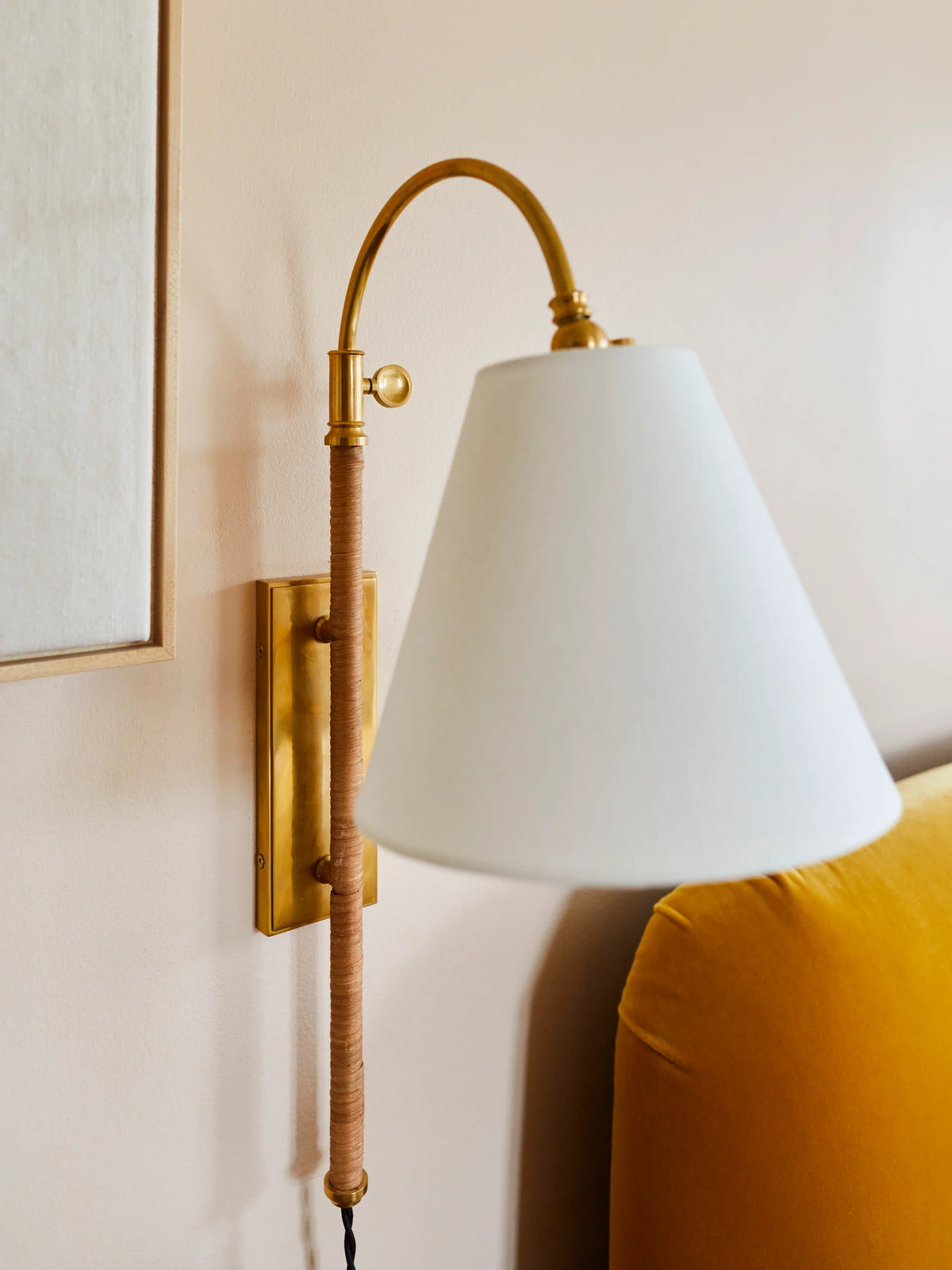 Westcott Arc Plug-In Wall Lamp styled in room — aged brass arc wall sconce with linen shade for bedroom or living room by Rachel Blindauer